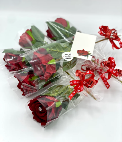 Individually wrapped red roses with decorative red ribbons