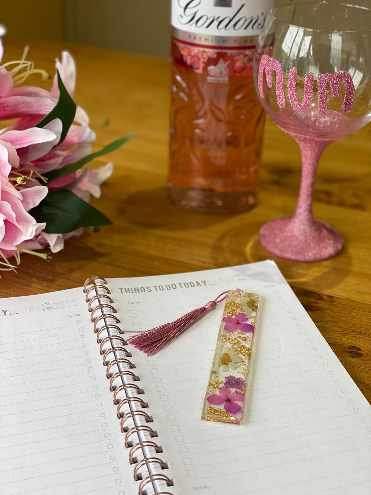Floral resin bookmark with pink tassel on a notebook
