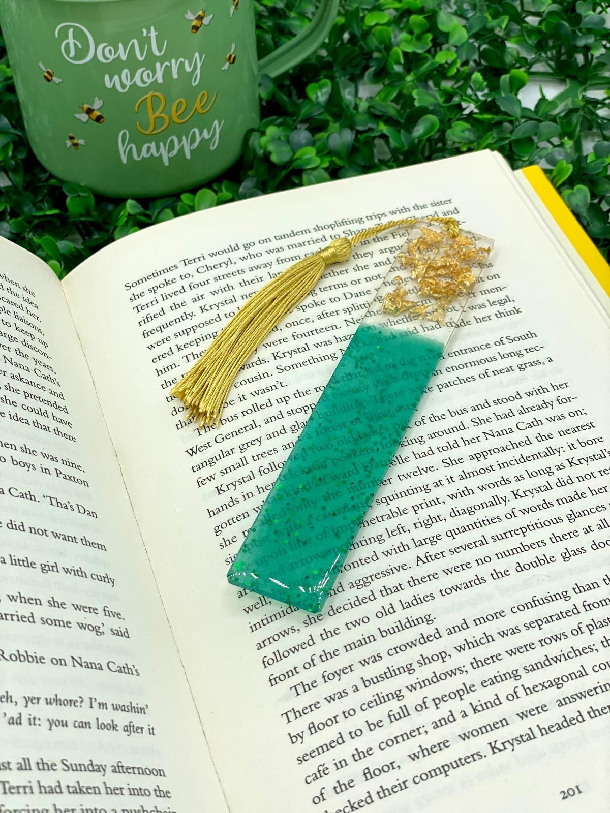 Green and gold resin bookmark resting on an open book